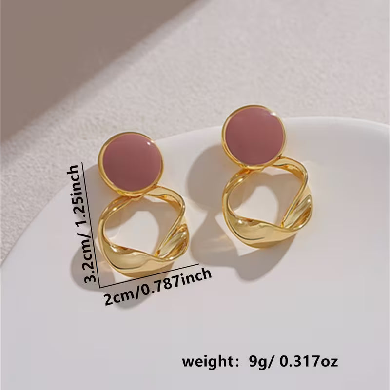 Aretes dorados con detalle circular en tono rosa