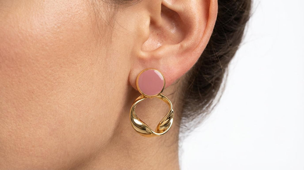 Aretes dorados con detalle circular en tono rosa