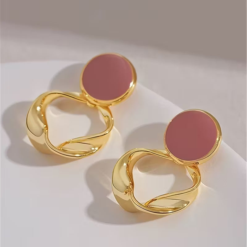 Aretes dorados con detalle circular en tono rosa