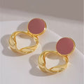 Aretes dorados con detalle circular en tono rosa